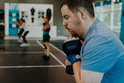 Man with boxing wraps performs a squat with a weight