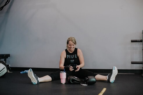 Woman sits on the floor putting her arm wraps on