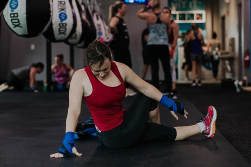 Woman performs a stretch on the floor