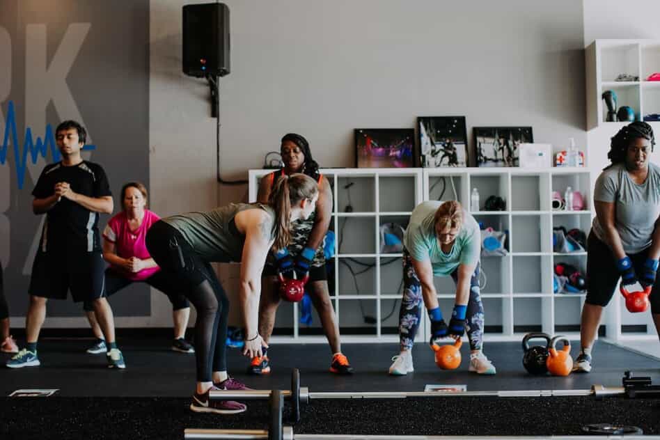 Class performs exercise using kettlebells