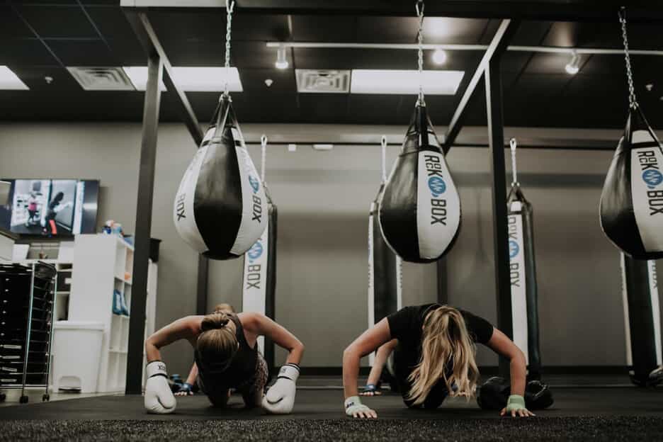 Two women perform push ups