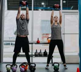 man and woman working out with kettle balls at rockbox fitness