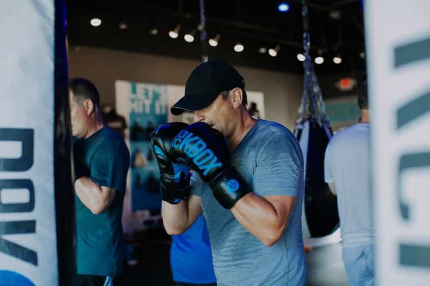 Man stands posed ready to hit a boxing bag