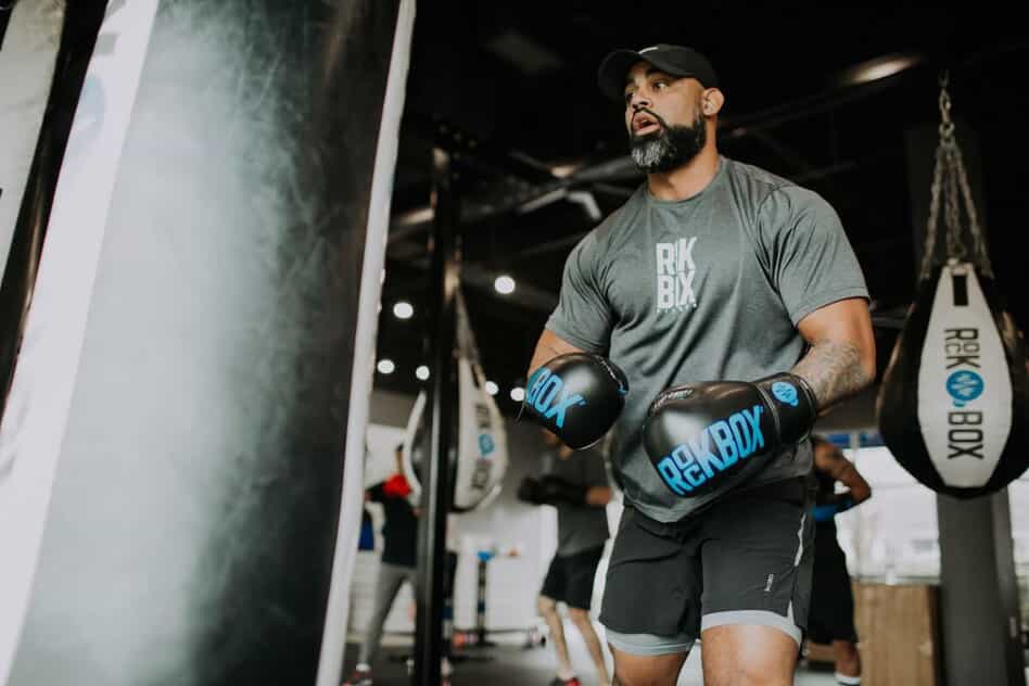 Man in a boxing gym preparing to punch a punching bag