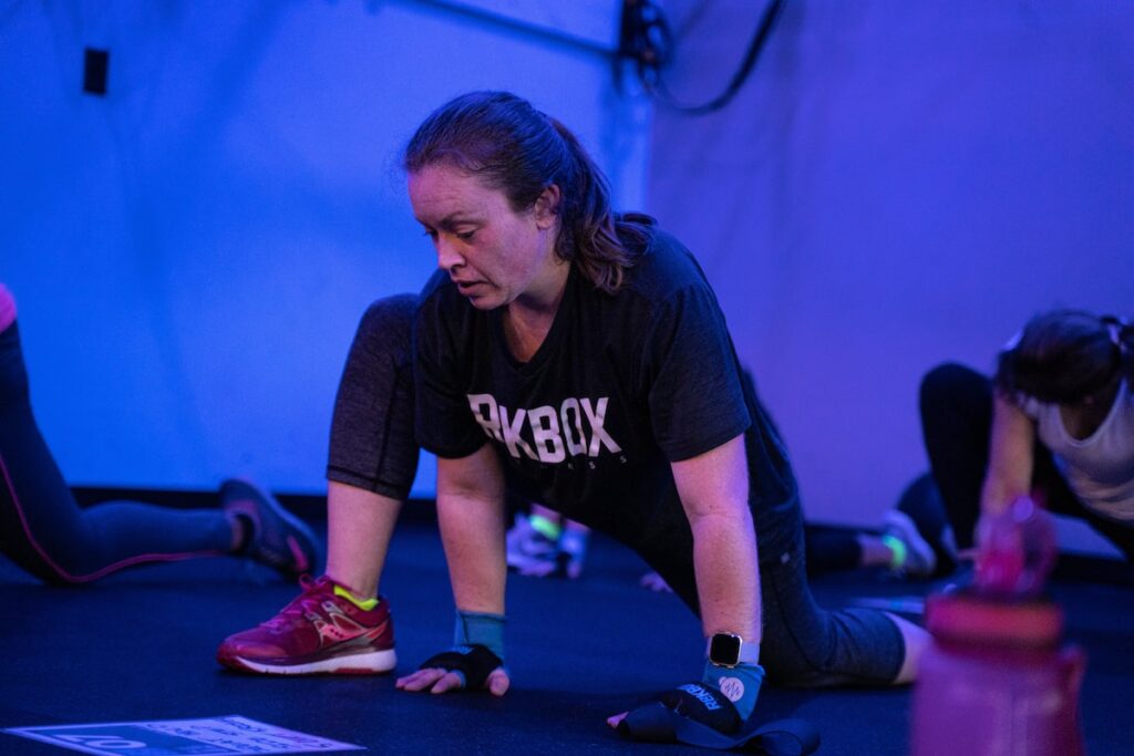 woman doing a hip flexor stretch during class cool down