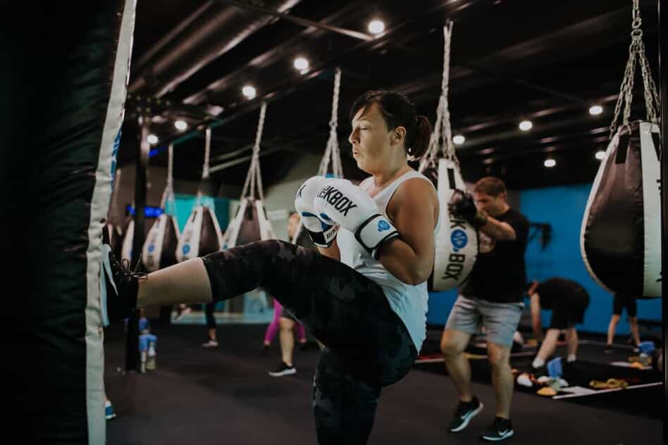 A woman kicks a punching bag