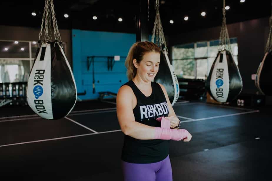 A woman wraps her hands with boxing wraps