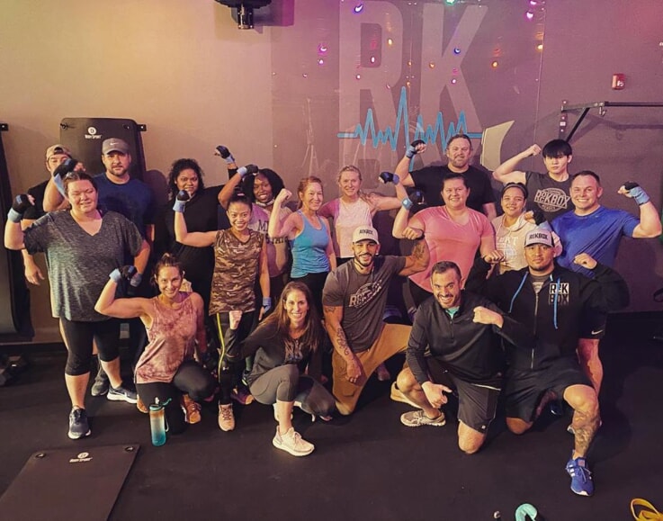 A rockbock fitness class flexes their biceps